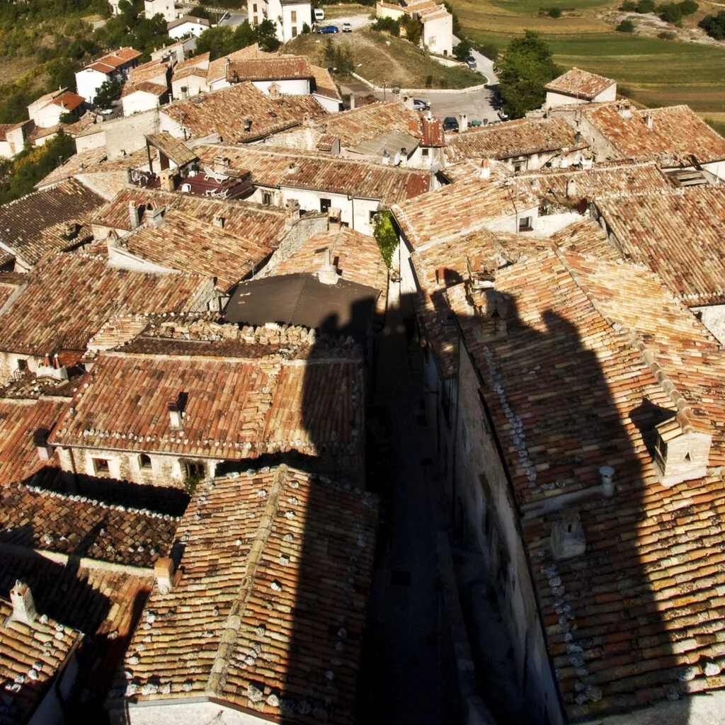 tetti in coppi di un borgo visti dall'alto con un vicolo stretto in ombra